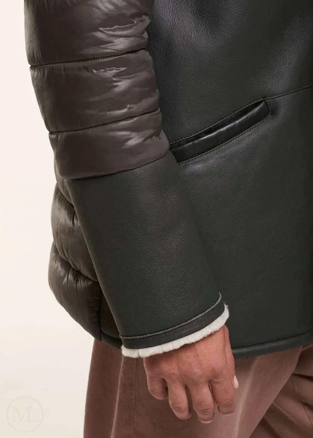 Close-up of a man wearing a brown shearling leather jacket with a white interior lining.