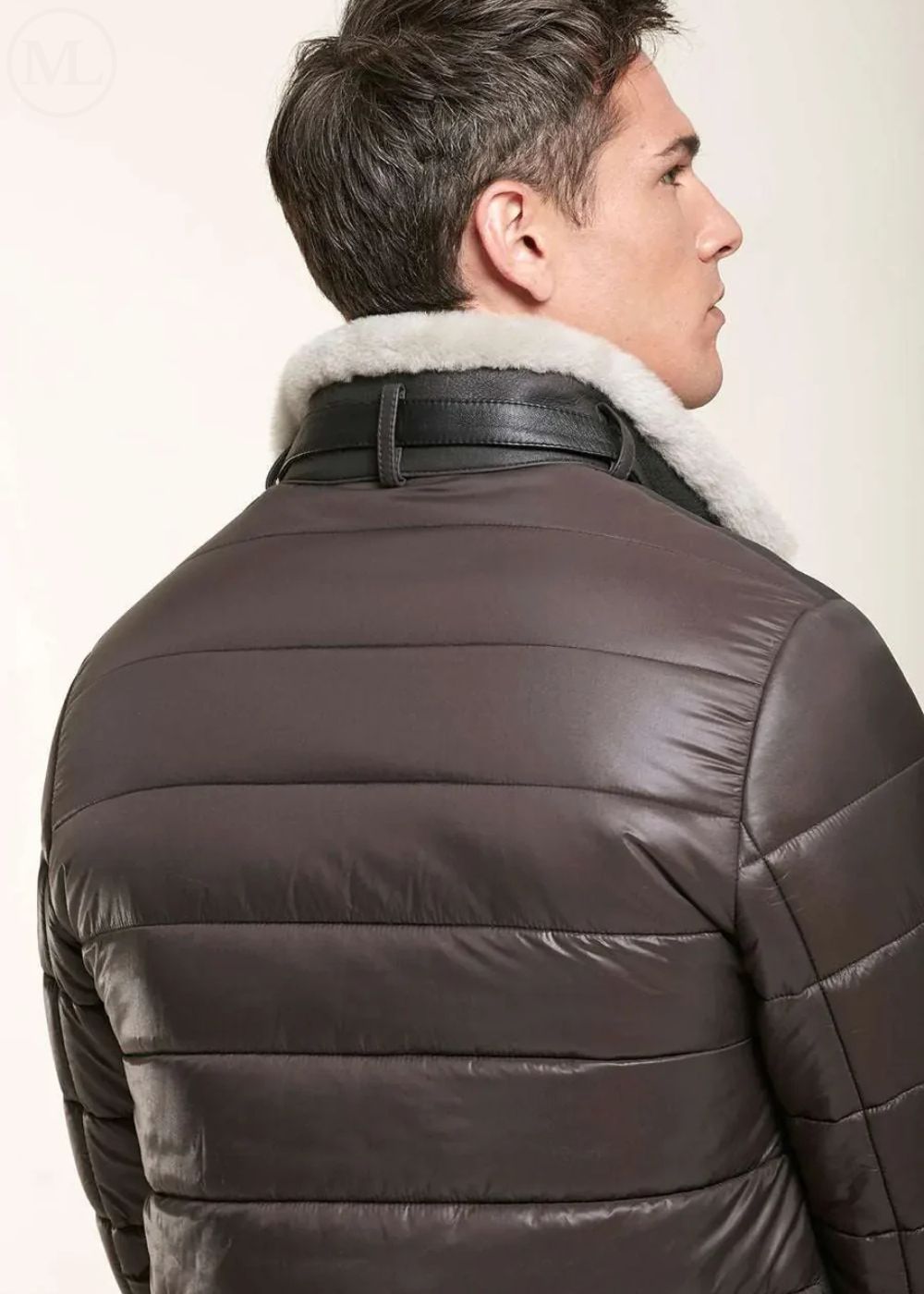 Man wearing a brown shearling leather jacket with white fur collar on a light background