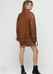 Woman wearing a Caramel brown leather biker jacket on a white background