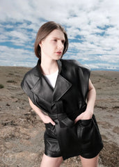 Women wearing a black leather vest outfit in a desert landscape